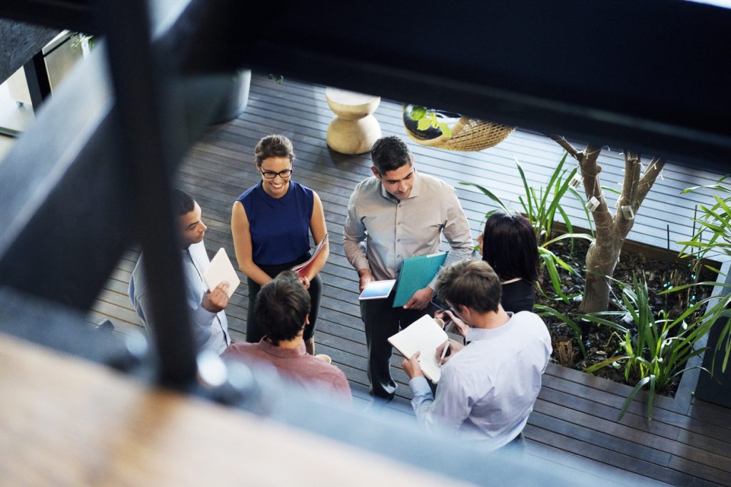 Collaborateurs discutant dans un hall d'entreprise